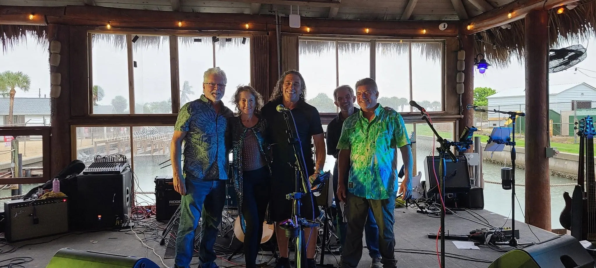 The Rita B Band lineup smiling together on stage before a show