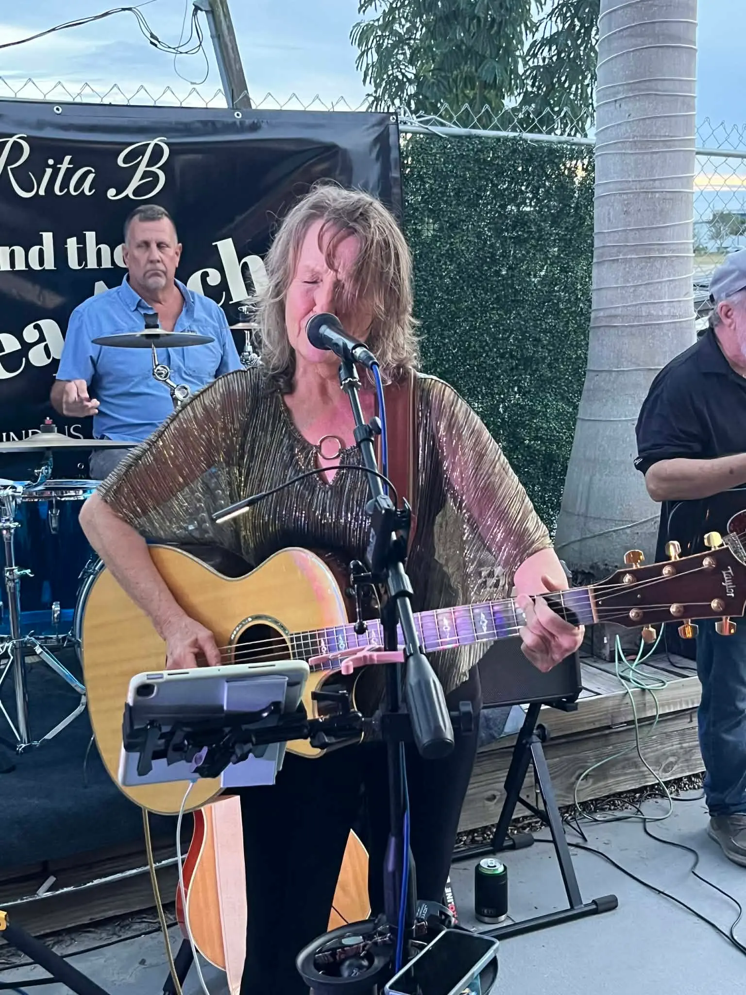 Rita B singing and playing acoustic guitar