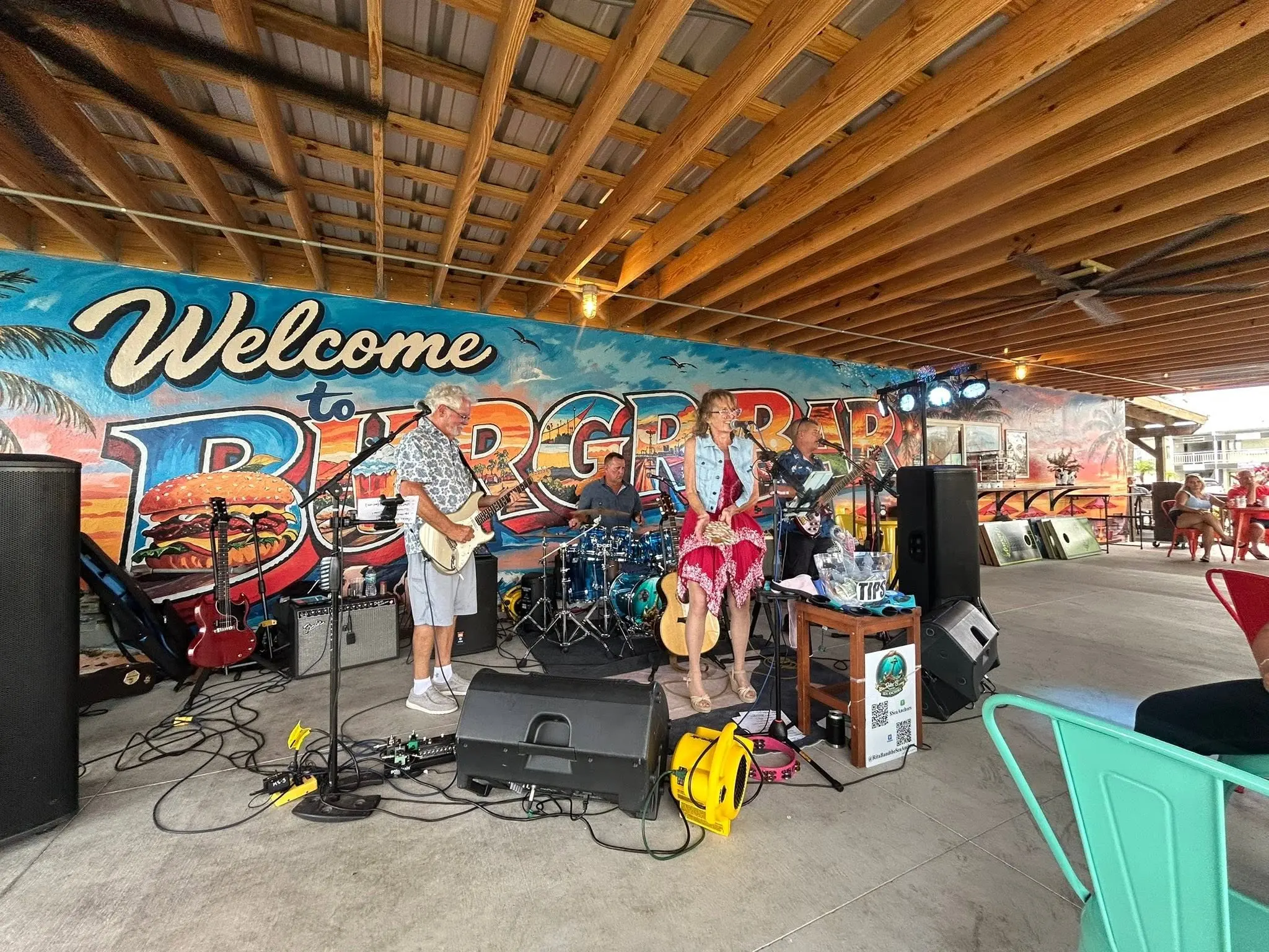 The band performing in front of a colorful Florida mural